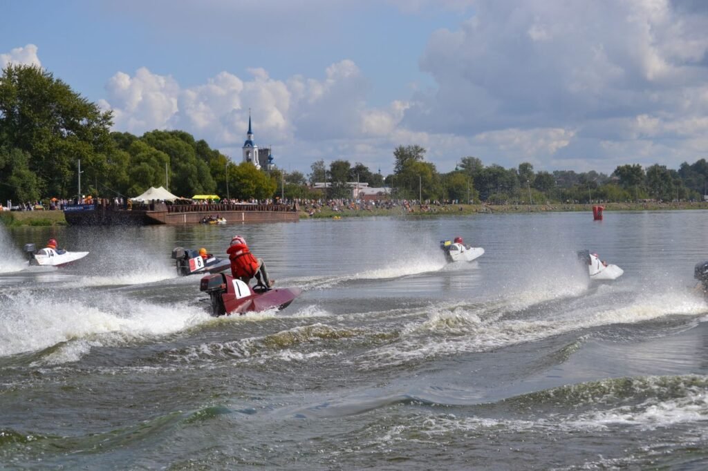 Dynamic powerboat race with riders speeding along a scenic river under a sunny sky.